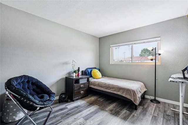 bedroom with wood finished floors and baseboards