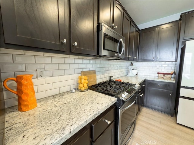 5485 San Roberto, San Diego, CA 92154 - kitchen with stainless steel appliances, light wood-type flooring, tasteful backsplash, light stone counters, and dark brown cabinetry