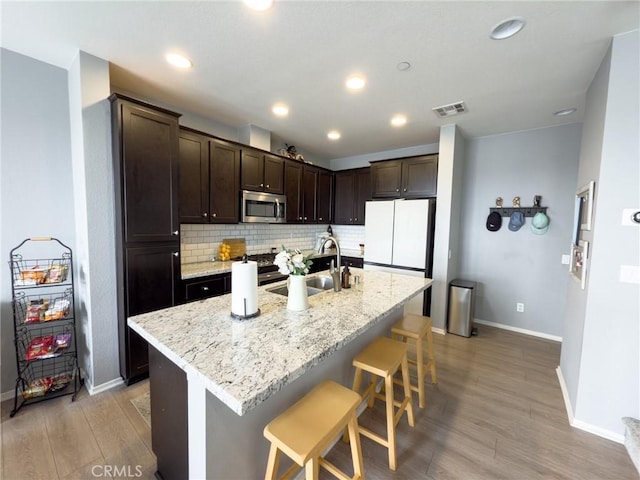 5485 San Roberto, San Diego, CA 92154 - kitchen with stainless steel microwave, a sink, baseboards, dark brown cabinets, and recessed lighting