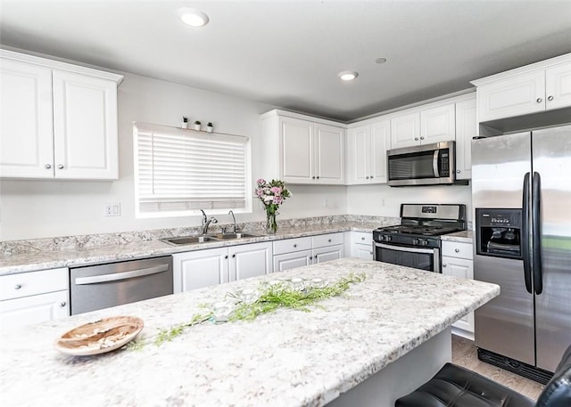 14205 Nicoles Way, Adelanto, CA 92301 - kitchen with stainless steel appliances, a sink, white cabinetry, wood finished floors, and recessed lighting