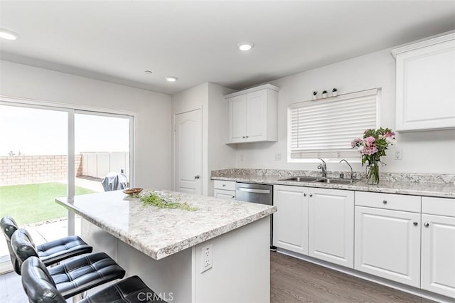 14205 Nicoles Way, Adelanto, CA 92301 - kitchen with a sink, a breakfast bar, wood finished floors, white cabinets, and light stone countertops
