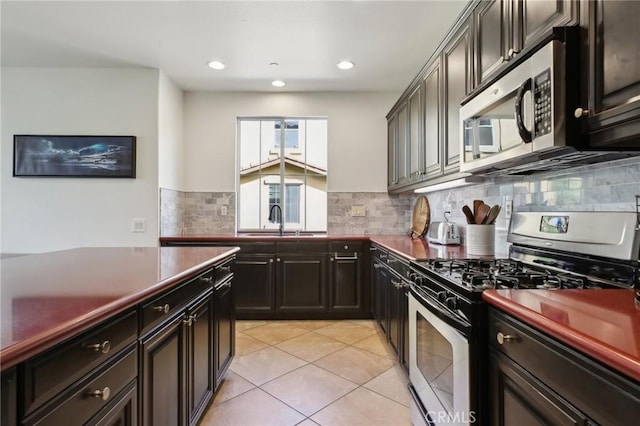 8519 E Kendra Loop, Orange, CA 92867 - kitchen featuring appliances with stainless steel finishes, a sink, backsplash, light tile patterned floors, and dark countertops