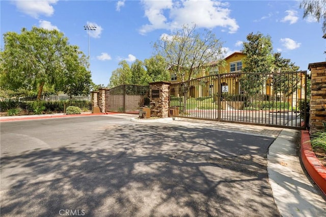 8519 E Kendra Loop, Orange, CA 92867 - view of asphalt street featuring a gate, curbs, and a gated entry