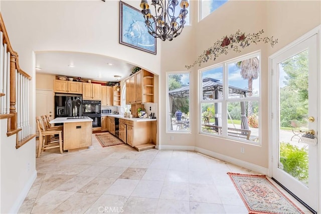 45975 Sandia Creek Dr, Temecula, CA 92590 - kitchen with open shelves, black appliances, a chandelier, baseboards, and arched walkways