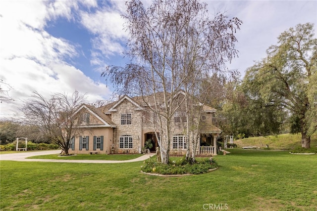 45975 Sandia Creek Dr, Temecula, CA 92590 - traditional home with stone siding, a front yard, covered porch, and stucco siding