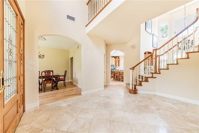 45975 Sandia Creek Dr, Temecula, CA 92590 - entryway with arched walkways, a towering ceiling, stairway, baseboards, and light tile patterned floors