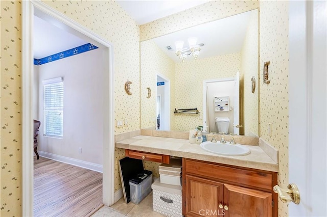 45975 Sandia Creek Dr, Temecula, CA 92590 - bathroom featuring wallpapered walls, toilet, a chandelier, wood finished floors, and vanity