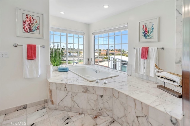 bathroom featuring a bath, recessed lighting, and baseboards