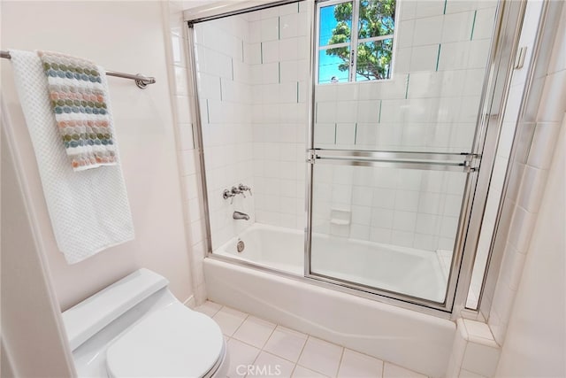 full bath featuring toilet, bath / shower combo with glass door, and tile patterned flooring