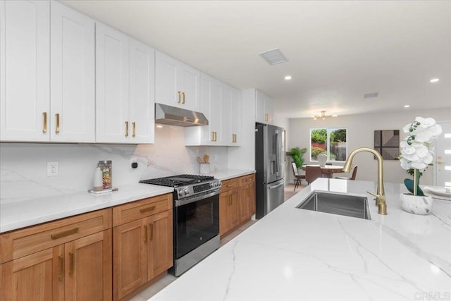 4566 Derrick Dr, San Diego, CA 92117 - kitchen with appliances with stainless steel finishes, a sink, under cabinet range hood, tasteful backsplash, and light stone countertops