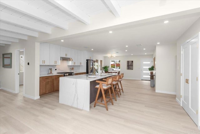 4566 Derrick Dr, San Diego, CA 92117 - kitchen with under cabinet range hood, light wood-style floors, baseboards, recessed lighting, and freestanding refrigerator
