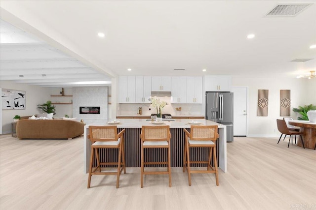 4566 Derrick Dr, San Diego, CA 92117 - kitchen featuring stainless steel refrigerator with ice dispenser, white cabinetry, light countertops, light wood-style flooring, and recessed lighting