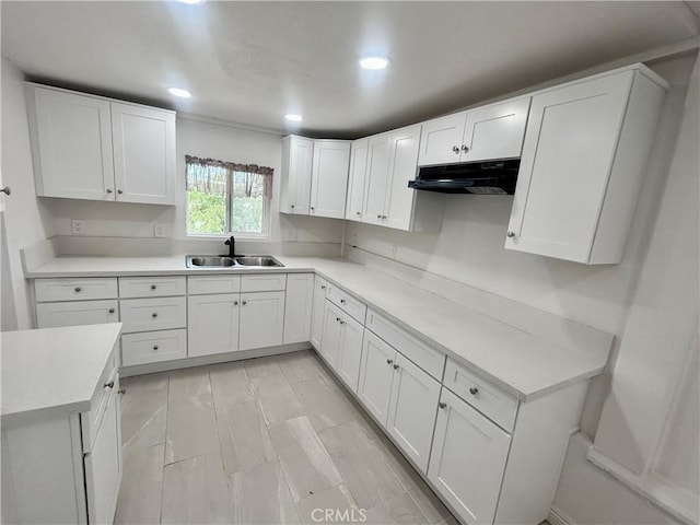 128130 E 1st St, Buttonwillow, CA 93206 - kitchen featuring under cabinet range hood, a sink, white cabinetry, light countertops, and recessed lighting