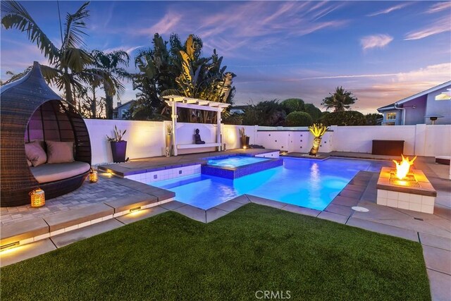 20191 Imperial Cove Ln, Huntington Beach, CA 92646 - pool at dusk featuring an outdoor fire pit, a patio area, and a pool with connected hot tub