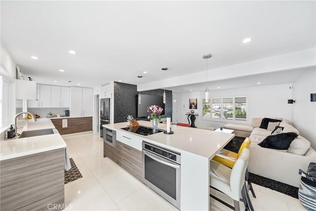 20191 Imperial Cove Ln, Huntington Beach, CA 92646 - kitchen featuring appliances with stainless steel finishes, a sink, open floor plan, modern cabinets, and light countertops