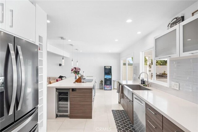 20191 Imperial Cove Ln, Huntington Beach, CA 92646 - kitchen with appliances with stainless steel finishes, a sink, modern cabinets, light tile patterned floors, and wine cooler