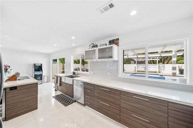 20191 Imperial Cove Ln, Huntington Beach, CA 92646 - kitchen with stainless steel dishwasher, modern cabinets, a sink, glass insert cabinets, and light countertops