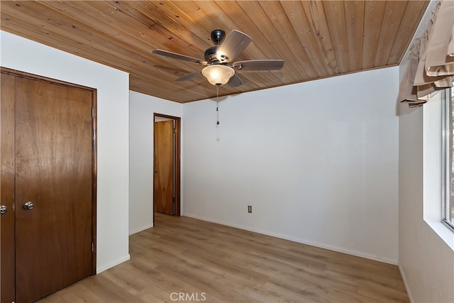 unfurnished bedroom featuring wood ceiling, light wood-style floors, baseboards, ceiling fan, and a closet