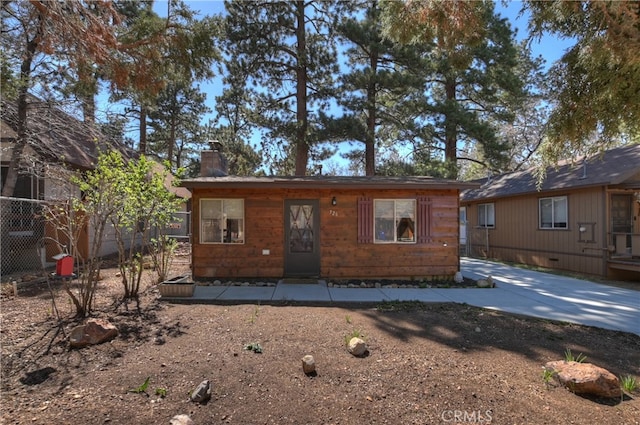view of front of house with a chimney and fence