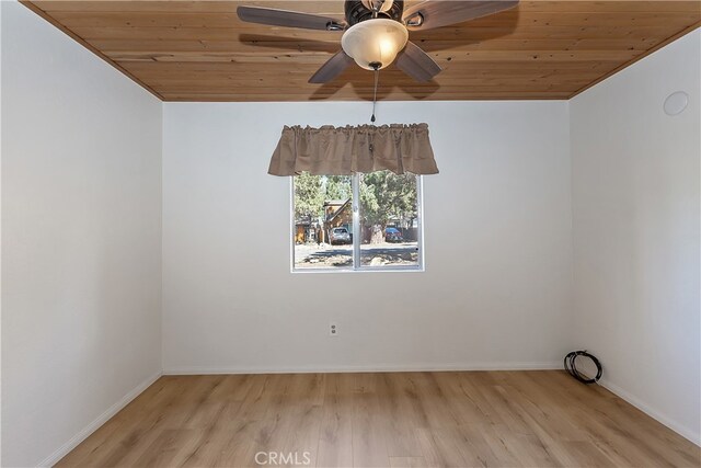 spare room with wood ceiling, wood finished floors, ceiling fan, and baseboards