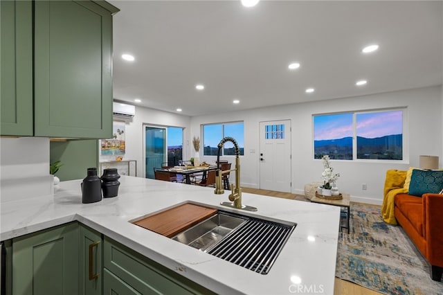 21408 Apollo Way, Desert Hot Springs, CA 92241 - kitchen featuring green cabinetry, a sink, light stone counters, open floor plan, and recessed lighting