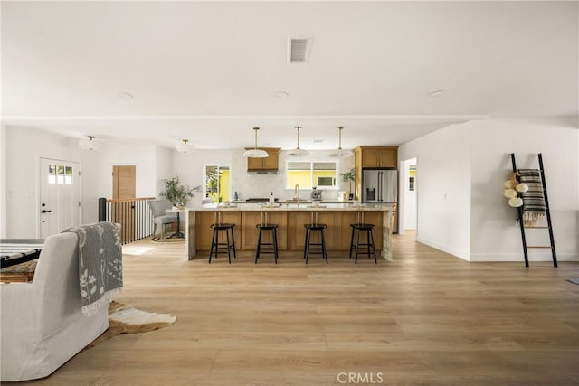 1909 Montair Ave, Long Beach, CA 90815 - kitchen featuring a kitchen breakfast bar, light wood-style floors, white microwave, and plenty of natural light