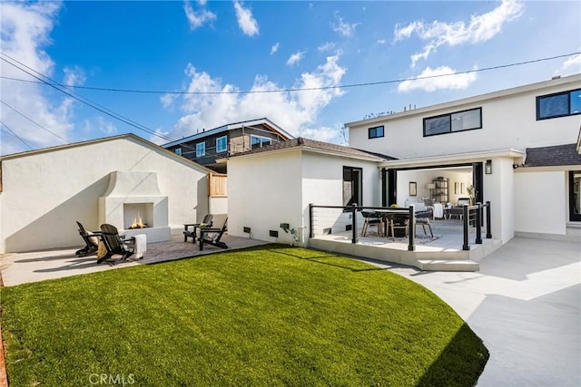 1909 Montair Ave, Long Beach, CA 90815 - back of house featuring a premium fireplace, a patio area, stucco siding, and a yard