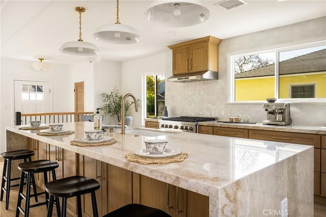 1909 Montair Ave, Long Beach, CA 90815 - kitchen with under cabinet range hood, a sink, decorative backsplash, range, and light stone countertops