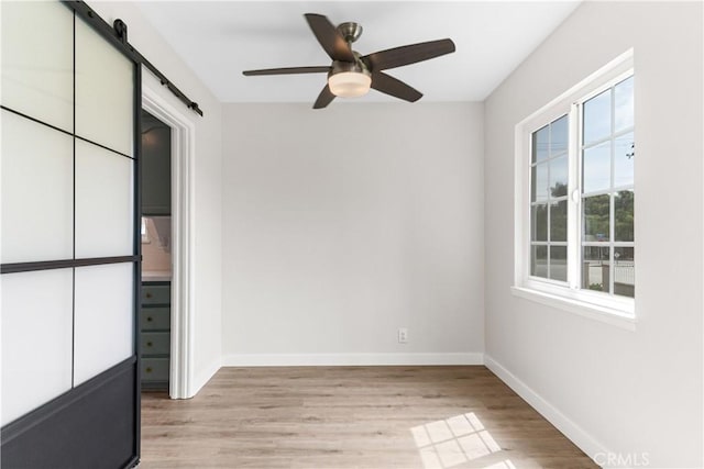 116 N Wildwood Ave, Glendora, CA 91741 - unfurnished bedroom featuring light wood-style flooring, a barn door, baseboards, and ceiling fan