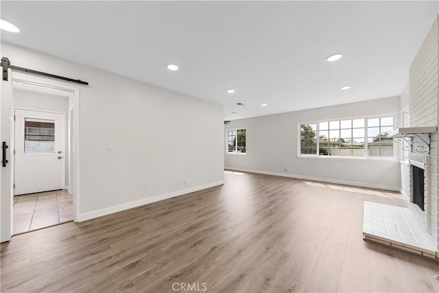 116 N Wildwood Ave, Glendora, CA 91741 - unfurnished living room with a barn door, a brick fireplace, wood finished floors, baseboards, and recessed lighting