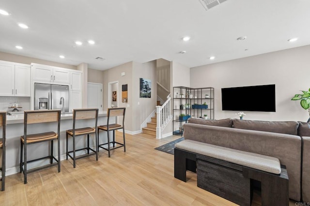 1211 Sunrise Vw Unit 104, San Marcos, CA 92078 - living room with stairway, light wood-style floors, recessed lighting, and baseboards