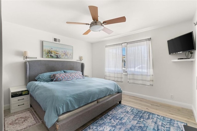 bedroom with light wood-type flooring, baseboards, and ceiling fan