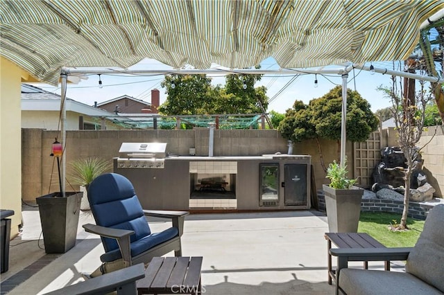 view of patio featuring exterior kitchen and a fenced backyard