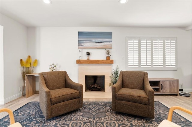 living area featuring wood finished floors, recessed lighting, a fireplace, and baseboards