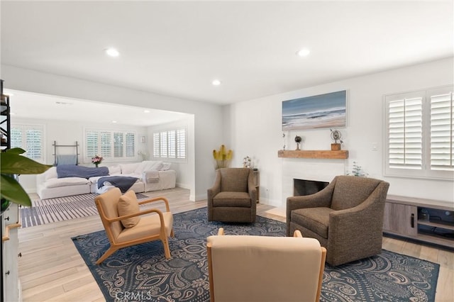 living room with wood finished floors, a fireplace, healthy amount of natural light, recessed lighting, and baseboards