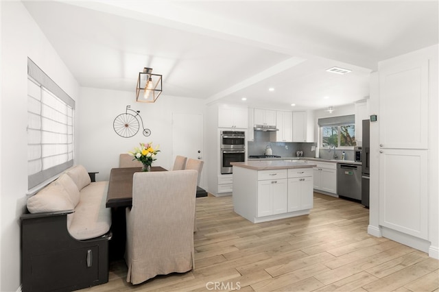 kitchen featuring stainless steel appliances, white cabinets, light wood finished floors, recessed lighting, and light countertops
