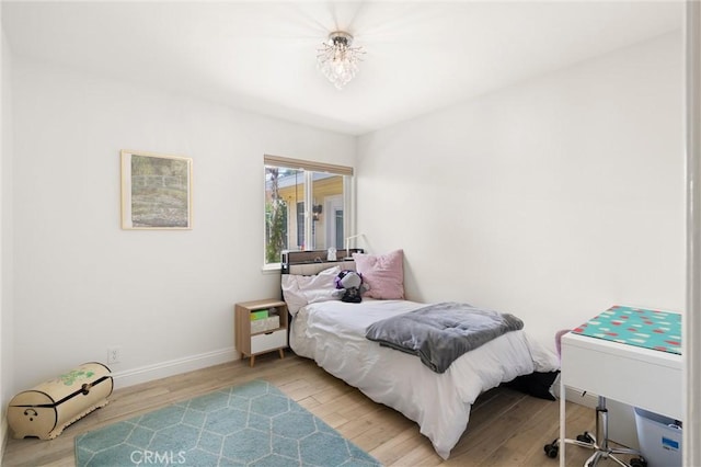 bedroom featuring wood finished floors and baseboards