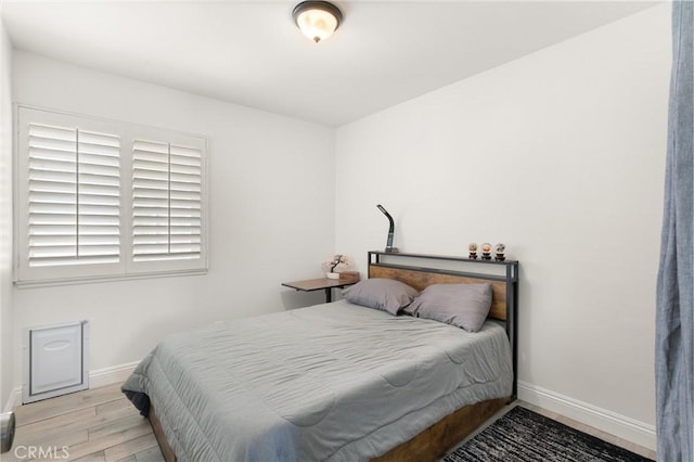 bedroom featuring baseboards and wood finished floors