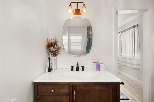 bathroom featuring vanity, wood finished floors, and baseboards