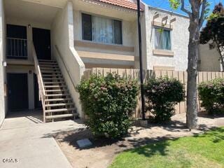 view of property featuring stairway and fence