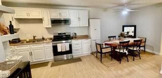 257 W Channel Islands Blvd, Port Hueneme, CA 93041 - kitchen with stainless steel appliances, ceiling fan, white cabinets, and light wood-type flooring
