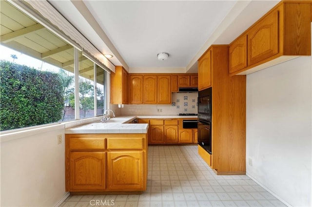 926 E Dalton Ave, Glendora, CA 91741 - kitchen with tile counters, brown cabinets, black oven, a sink, and light flooring