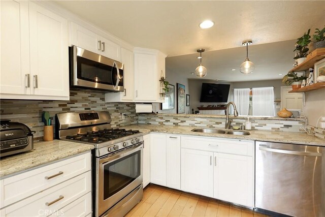290 Victoria St Unit 19, Costa Mesa, CA 92627 - kitchen with appliances with stainless steel finishes, a sink, tasteful backsplash, white cabinetry, and hanging light fixtures