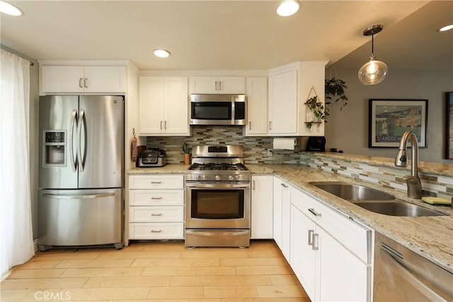 290 Victoria St Unit 19, Costa Mesa, CA 92627 - kitchen featuring stainless steel appliances, a sink, decorative backsplash, white cabinetry, and light wood-style floors