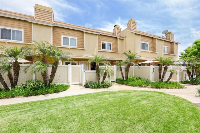 290 Victoria St Unit 19, Costa Mesa, CA 92627 - view of property featuring a gate, a chimney, and stucco siding