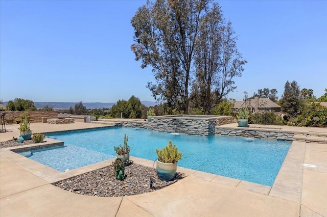 view of swimming pool featuring a pool with connected hot tub and a patio