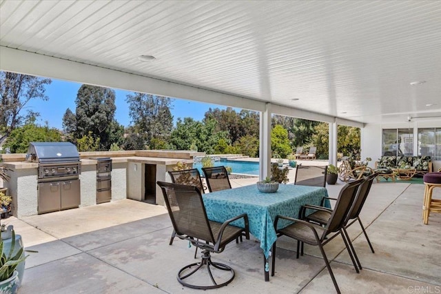 view of patio / terrace with exterior kitchen, a grill, outdoor dining area, and an outdoor pool