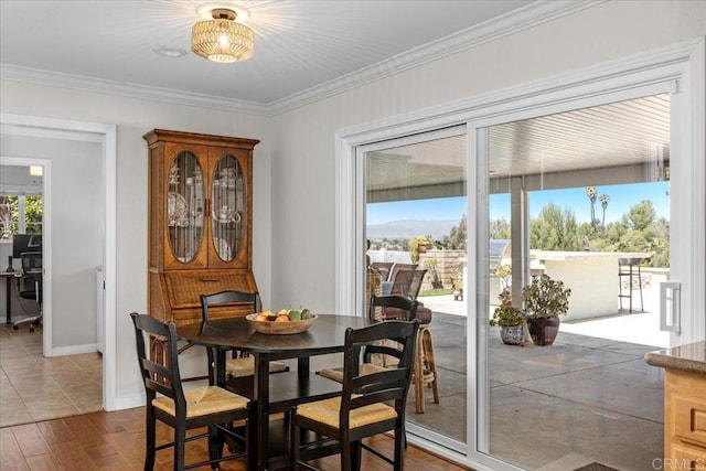 dining space featuring ornamental molding, wood finished floors, and baseboards