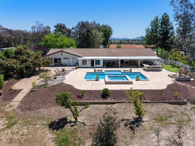 view of pool with a patio area and a pool with connected hot tub