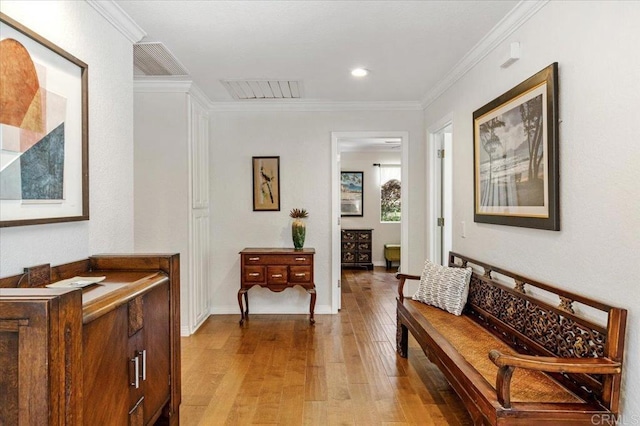 hall featuring light wood-style flooring, crown molding, baseboards, and recessed lighting
